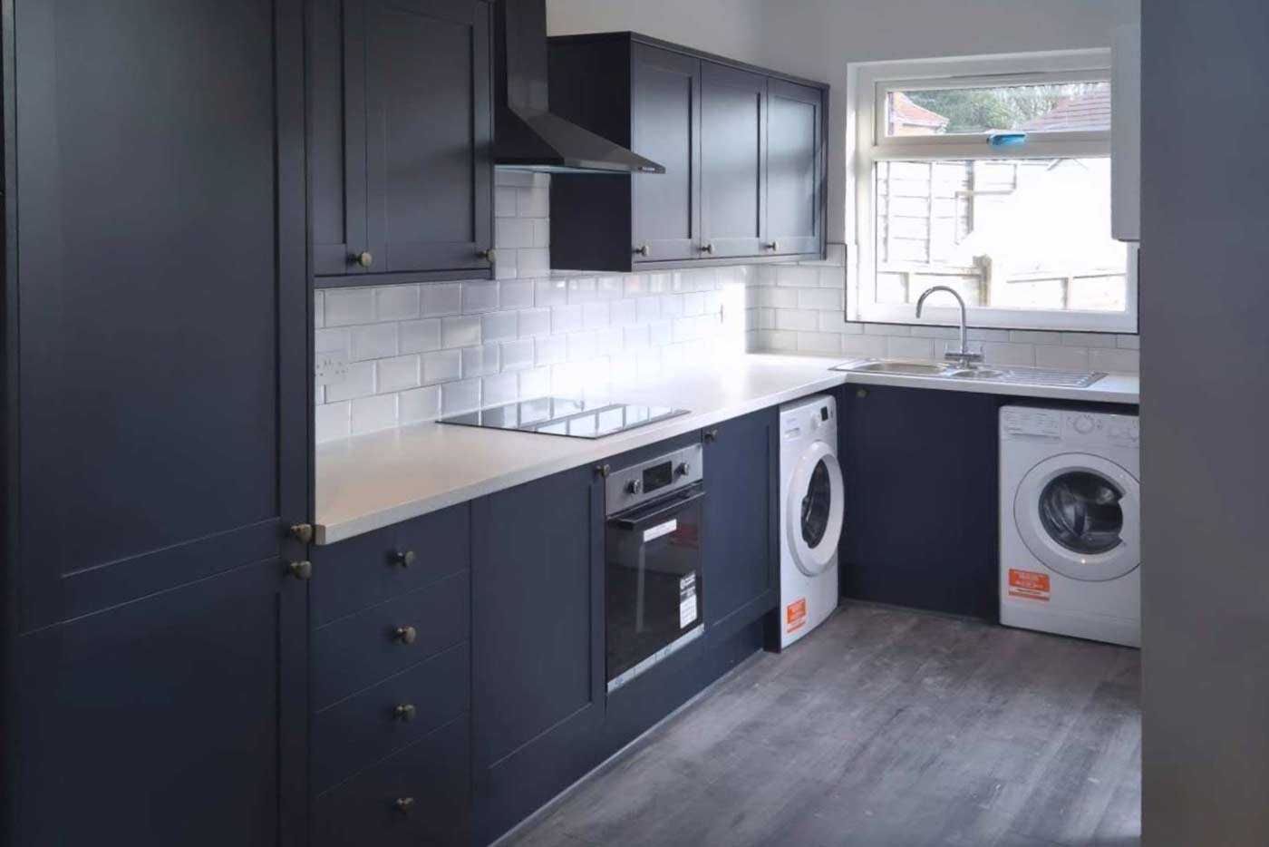 A blue and white tiled, shaker style kitchen installed by Prima Construction, professional kitchen fitters in Stockport.