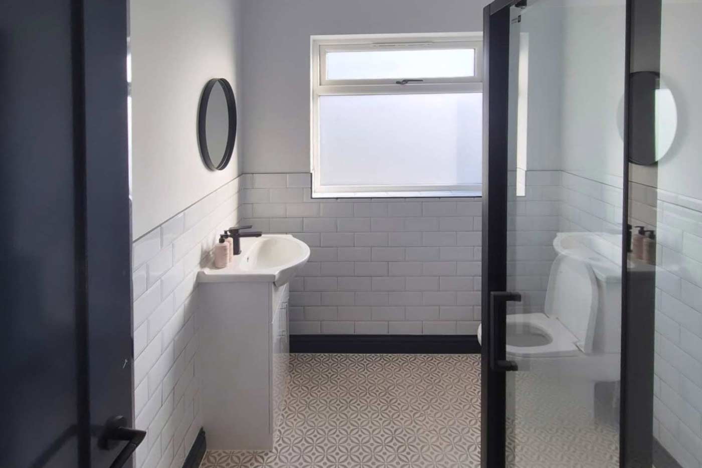 A blue and white tiled, traditional en-suite bathroom installed by Prima Construction, professional bathroom fitters in Stockport.