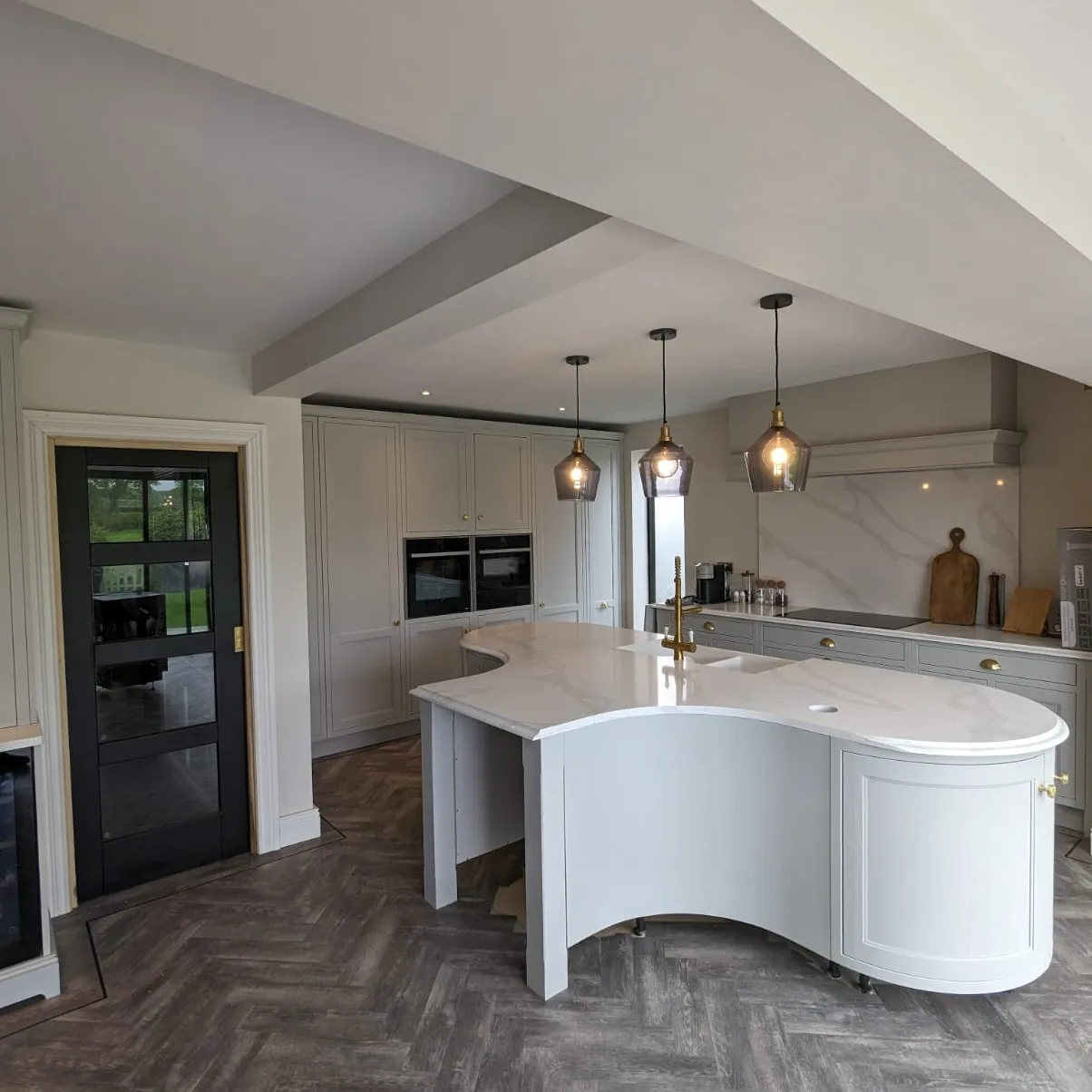Curved kitchen island installed in a Stockport kitchen by Prima Construction