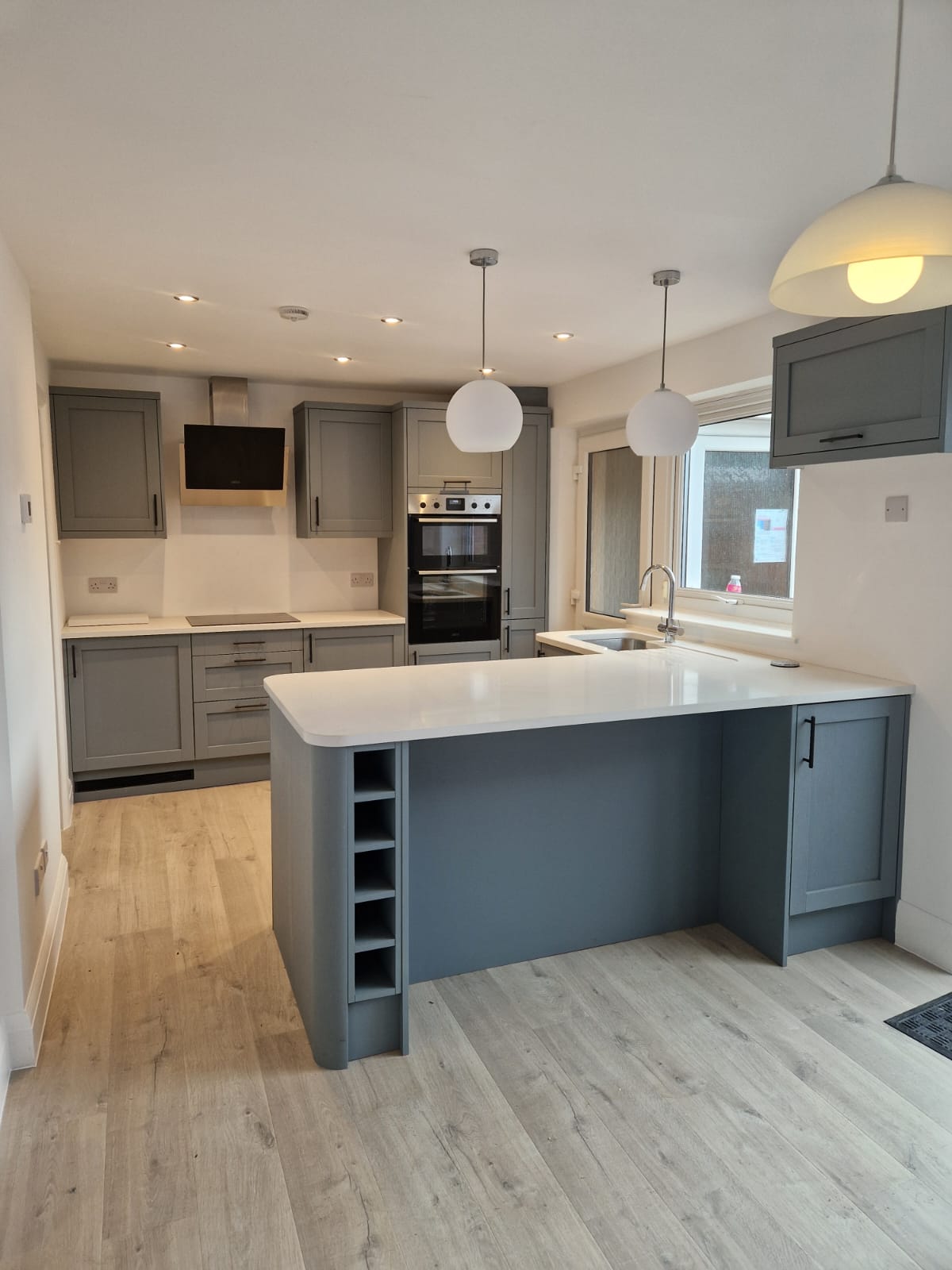 Grey kitchen with wine rack fitted in Stockport by Prima Construction