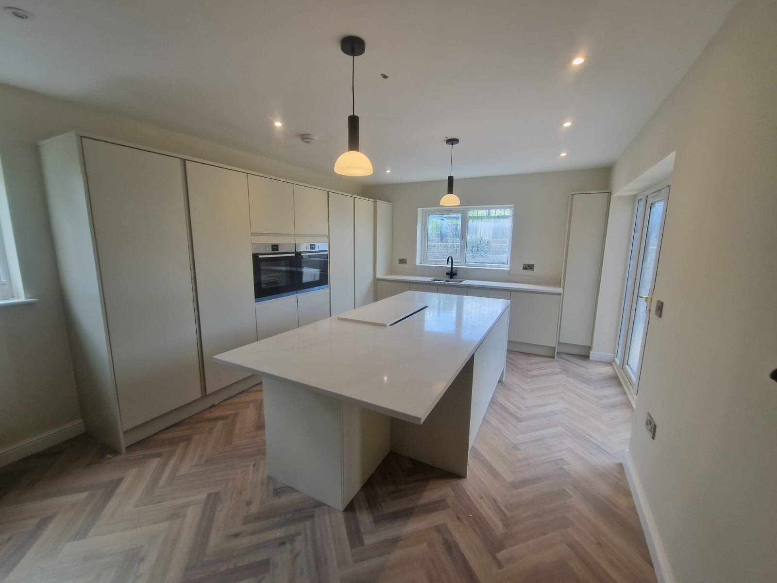Newly fitted white modern kitchen and island in a Stockport Home