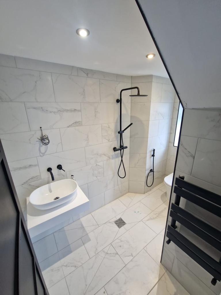 White marble with black accessories wetroom installation by Prima Construction