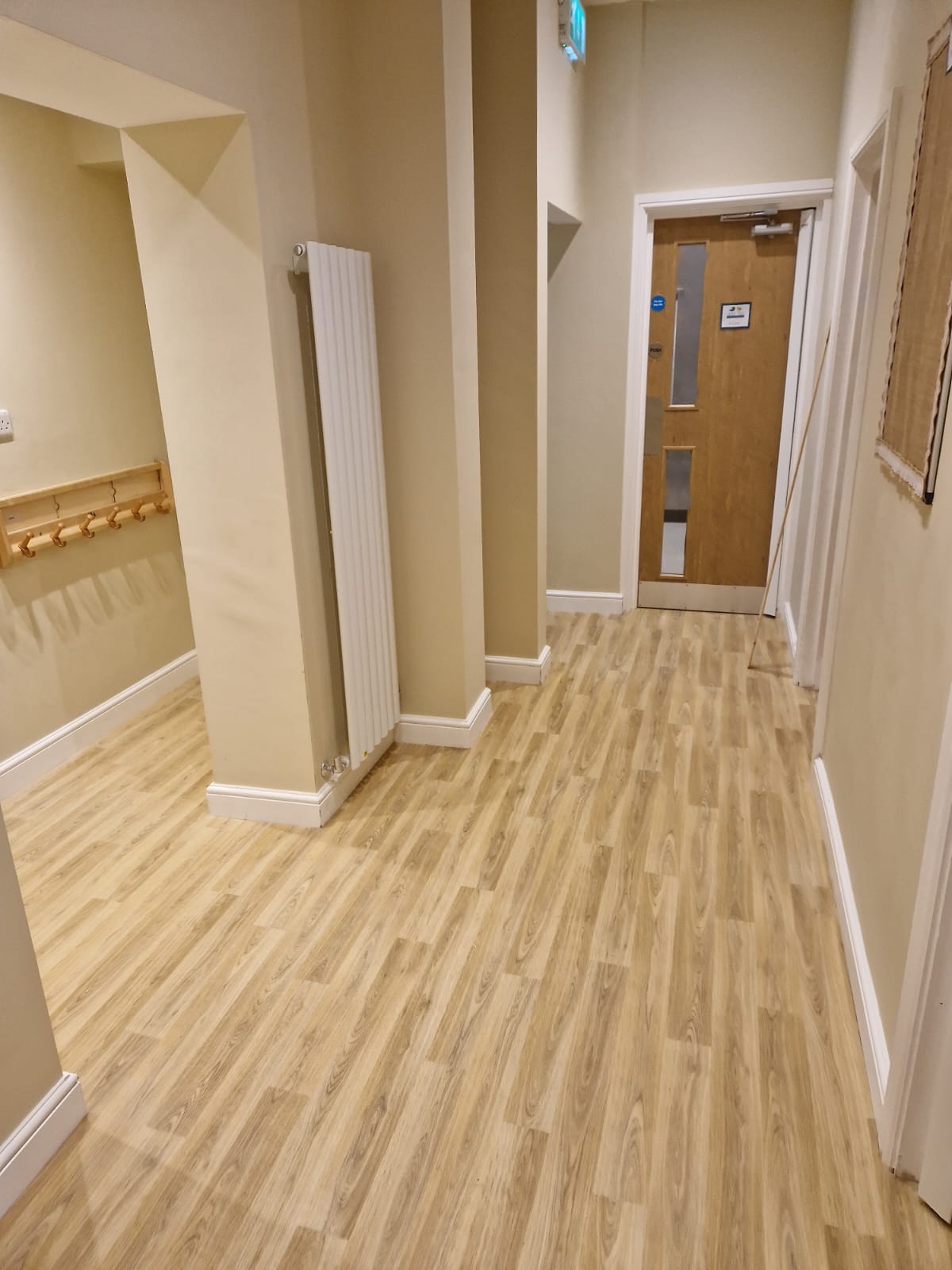 Corridor with fire doors and coat pegs on the nursery refurbishment project